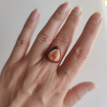 Detalle del patrón "ojo" de la cornalina: anillos concéntricos naranja y melocotón formando un iris