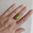 Cabujón ópalo verde natural 25x13 mm junto a herramienta de lapidario para referencia de escala