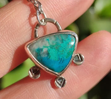 Colgante ovalado de crisocola en plata con 3 monedas flechadas colgantes – Vista frontal y detalle de grabados